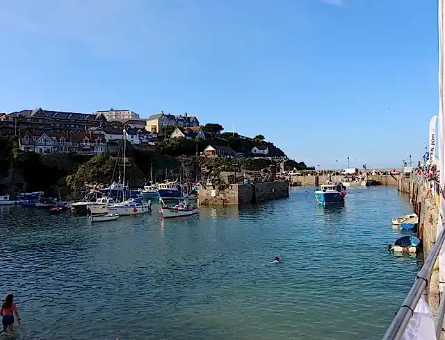 A view of a Cornish harbour with a boat sailing through it