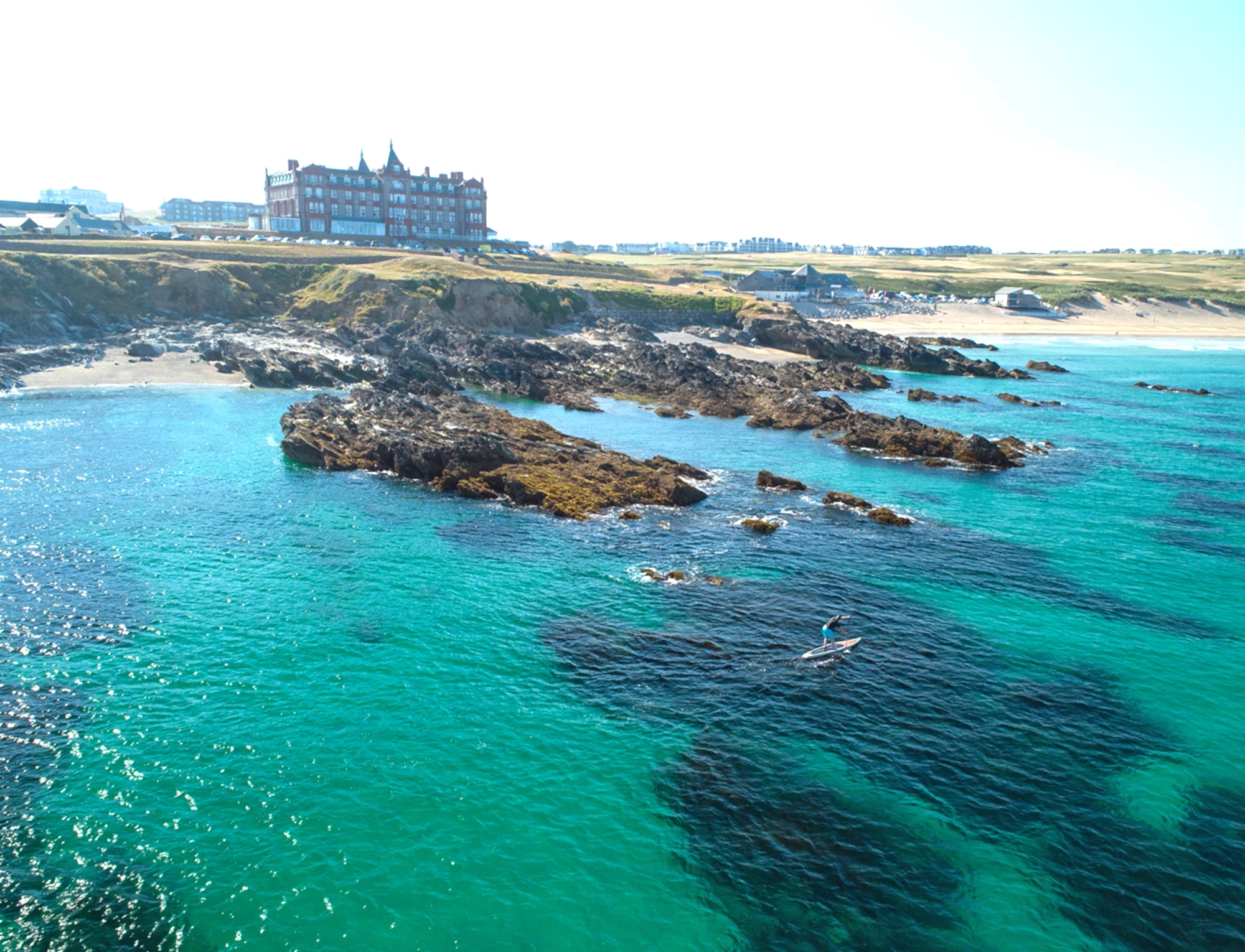 A view of the Headland Hotel and the sea on a sunny day