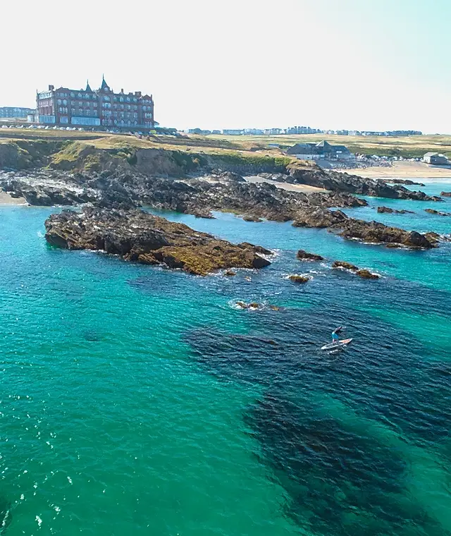 A view of the Headland Hotel and the sea on a sunny day
