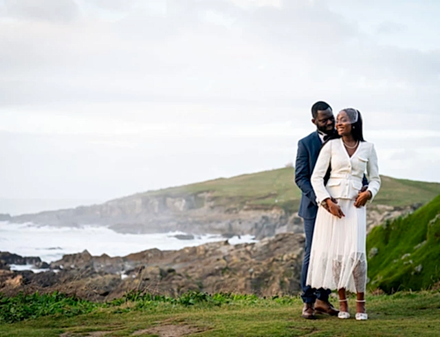 A bride and groom embracing on the cliffs outside the Headland hotel
