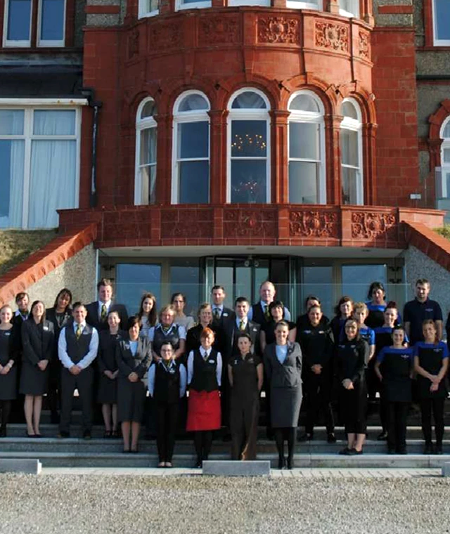 A group of people assembled outside the Headland Hotel