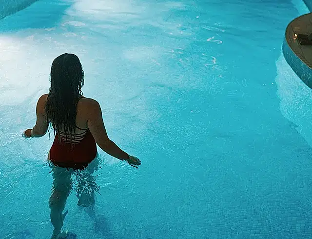 A woman in a swimming pool at night