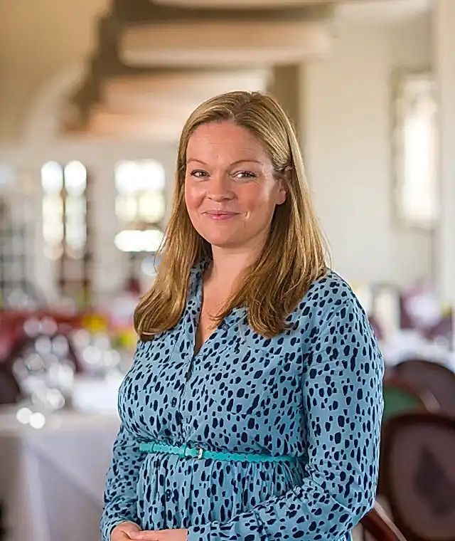 A lady standing in a restaurant at the Headland Hotel