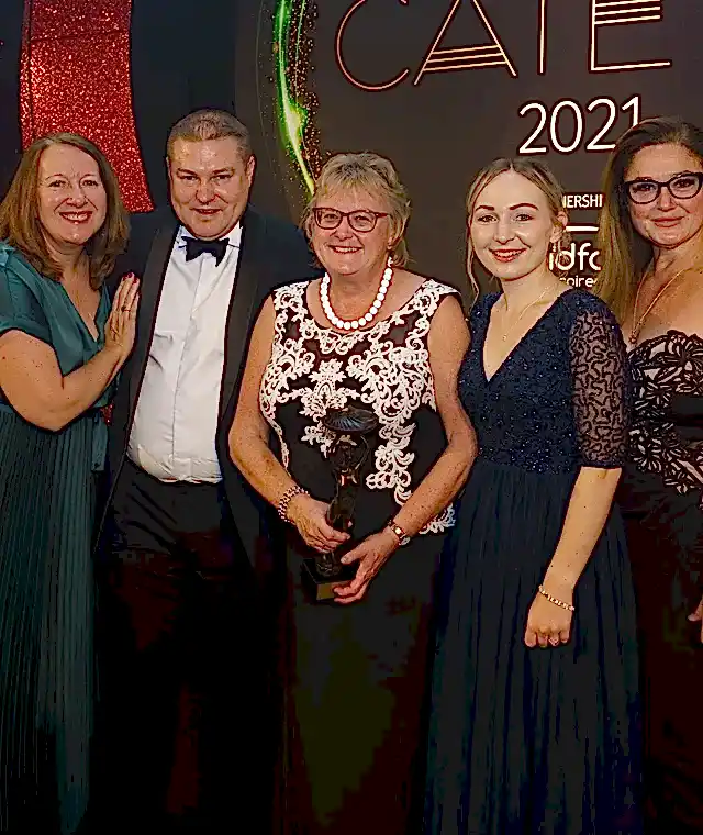 Five people standing in front of the Cateys Awards Sign