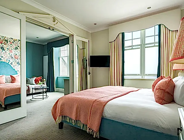 a view inside the luxury ocean suite with a bed, television and window