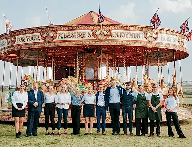 a crowd of people in front of a merry go round