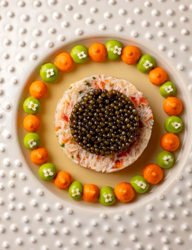 Ugly butterly fine dining crab dish on a circular dish.