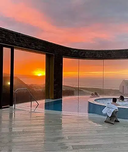 A view of the swimming pool in the Headland Hotel at sunset