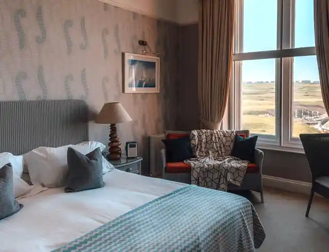 a luxury bedroom in the hotel with a sofa and a bed with a view out of the window