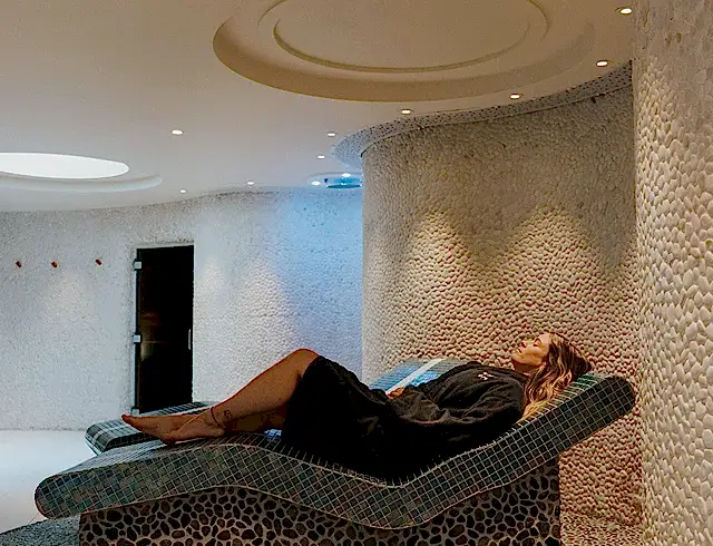 A woman relaxing on a deck chair in a spa