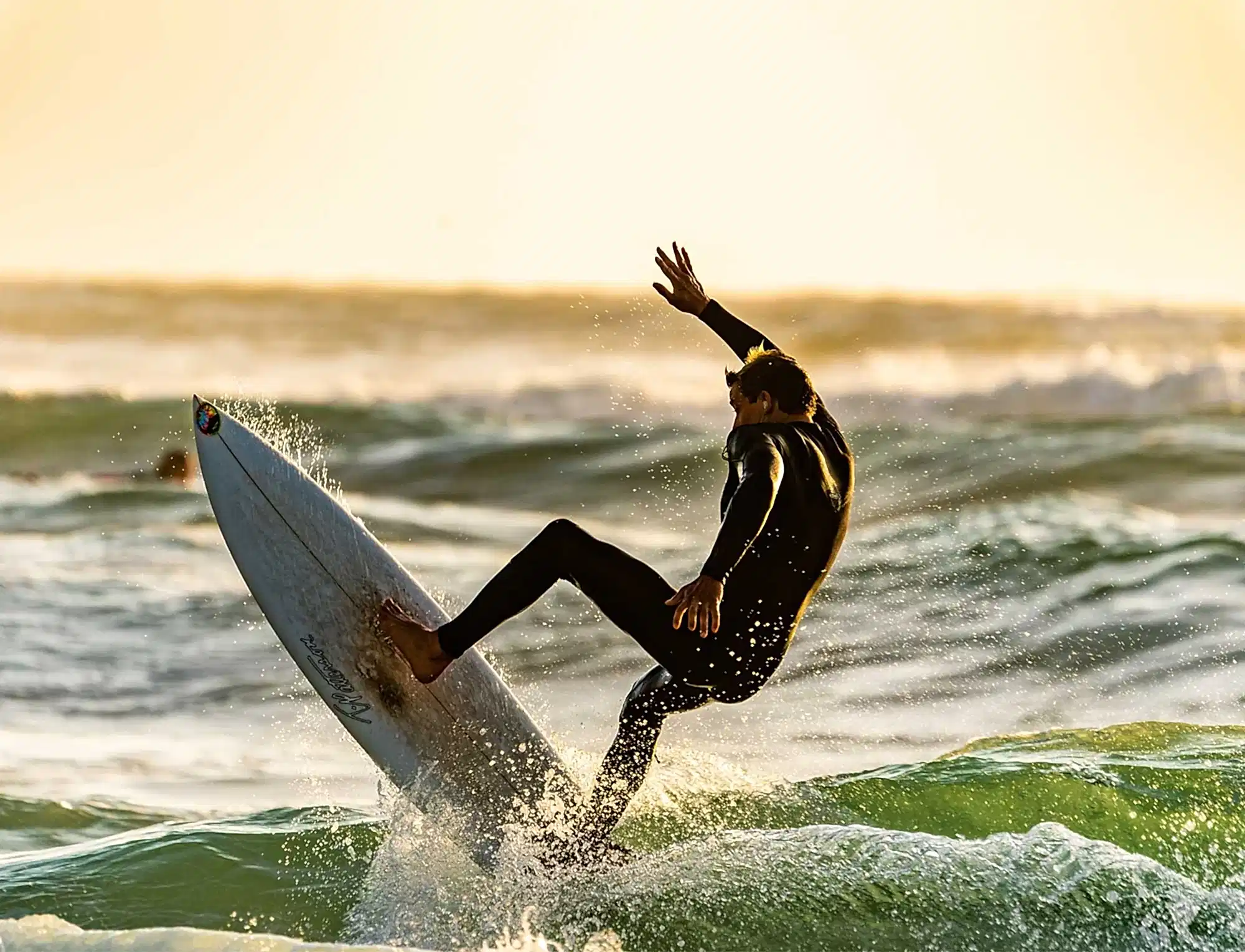 An image of a person surfing a wave on a sunny day. 