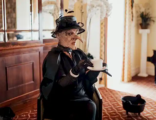 a witch holding a cup of tea