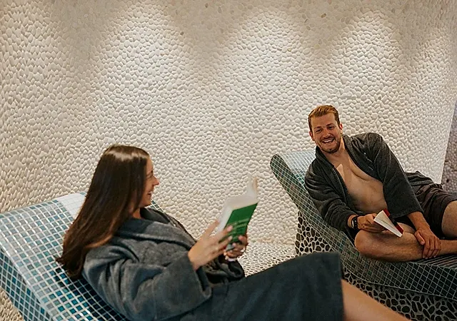 two people talking lying on deck chairs in a spa room