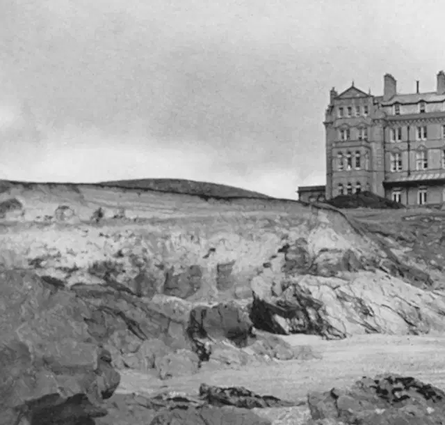 Black and white vintage style image of The Headland Hotel on the cliff edge next to Fistral Beach.