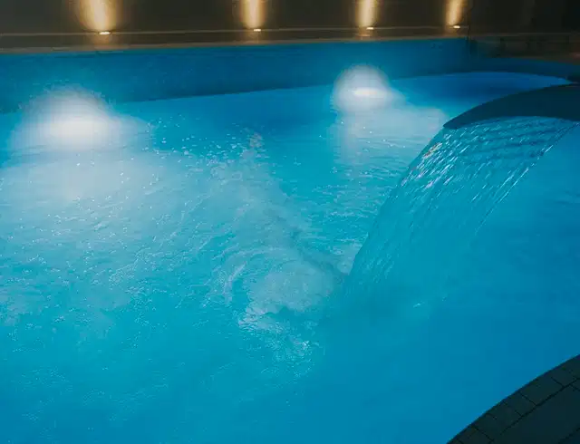Swimming pool at night with water pouring into it