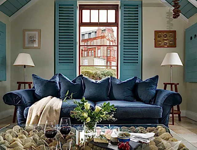 a large navy blue sofa with a window overlooking a building in the background